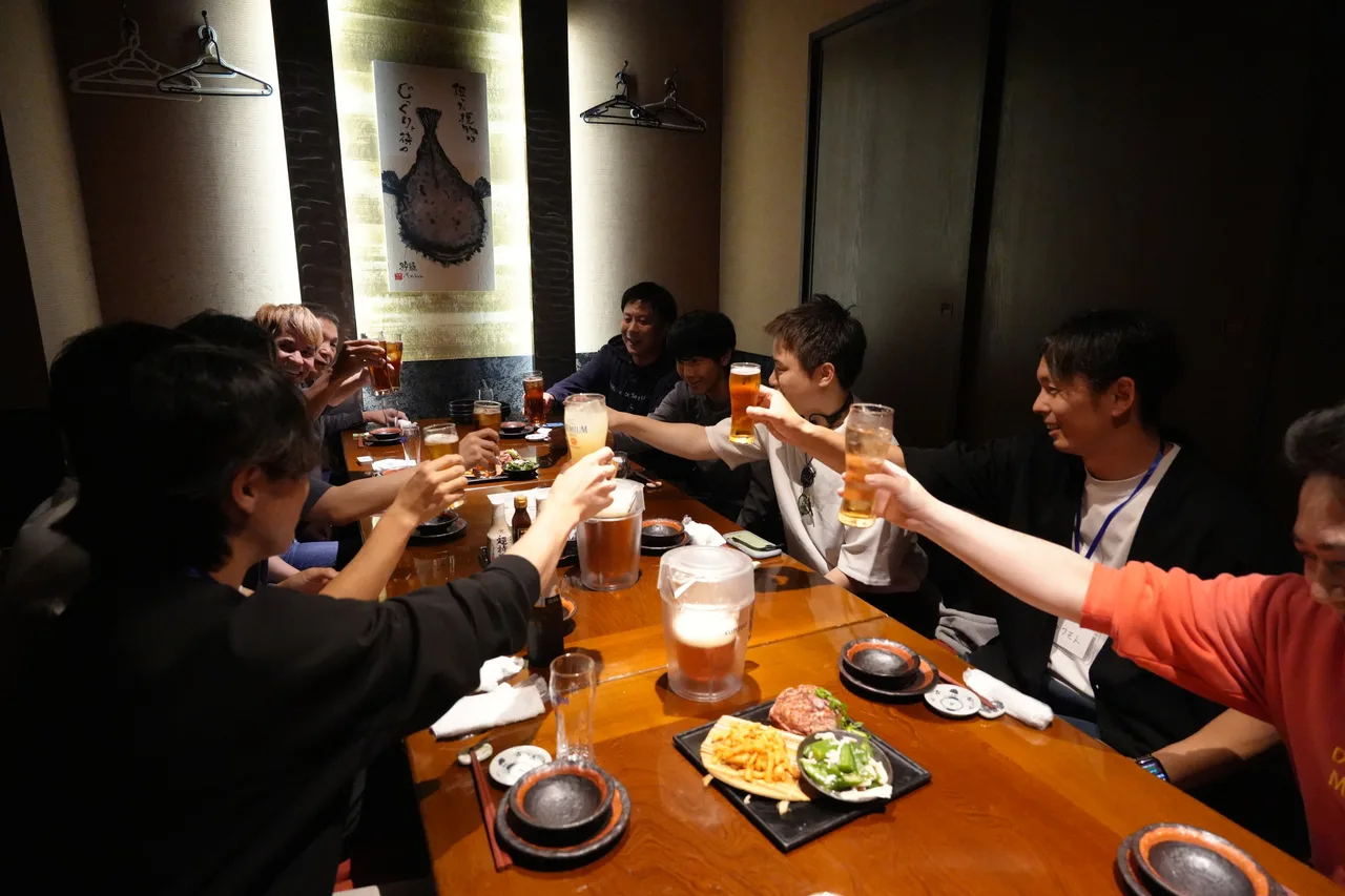 1日目の懇親会で、グラスを合わせて乾杯する参加者とスタッフ