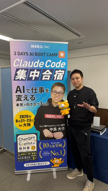 会場のClaude Code集中合宿バナーの隣に立つ中島大介